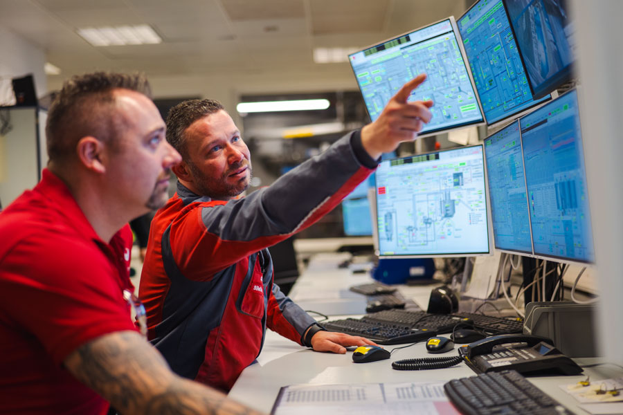 2 Mitarbeiter vor Computer-Bildschirmen